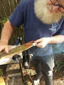 Picture of man working on a gift on his outside work table