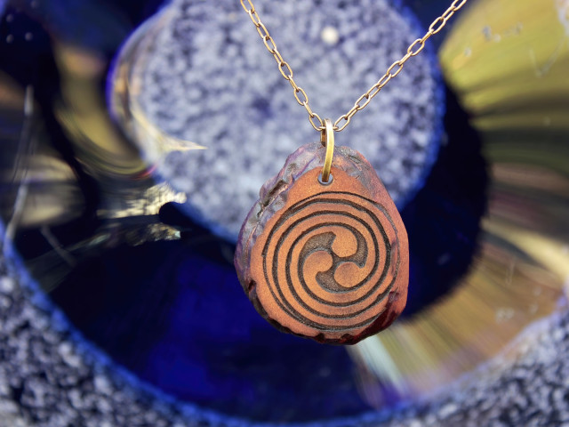 Close-up of pendant in front of blue glass background